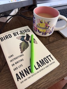 The cover of the book Bird by Bird by Anne Lamott, with a green marker on top of the book. A coffee cup sits next to the book.